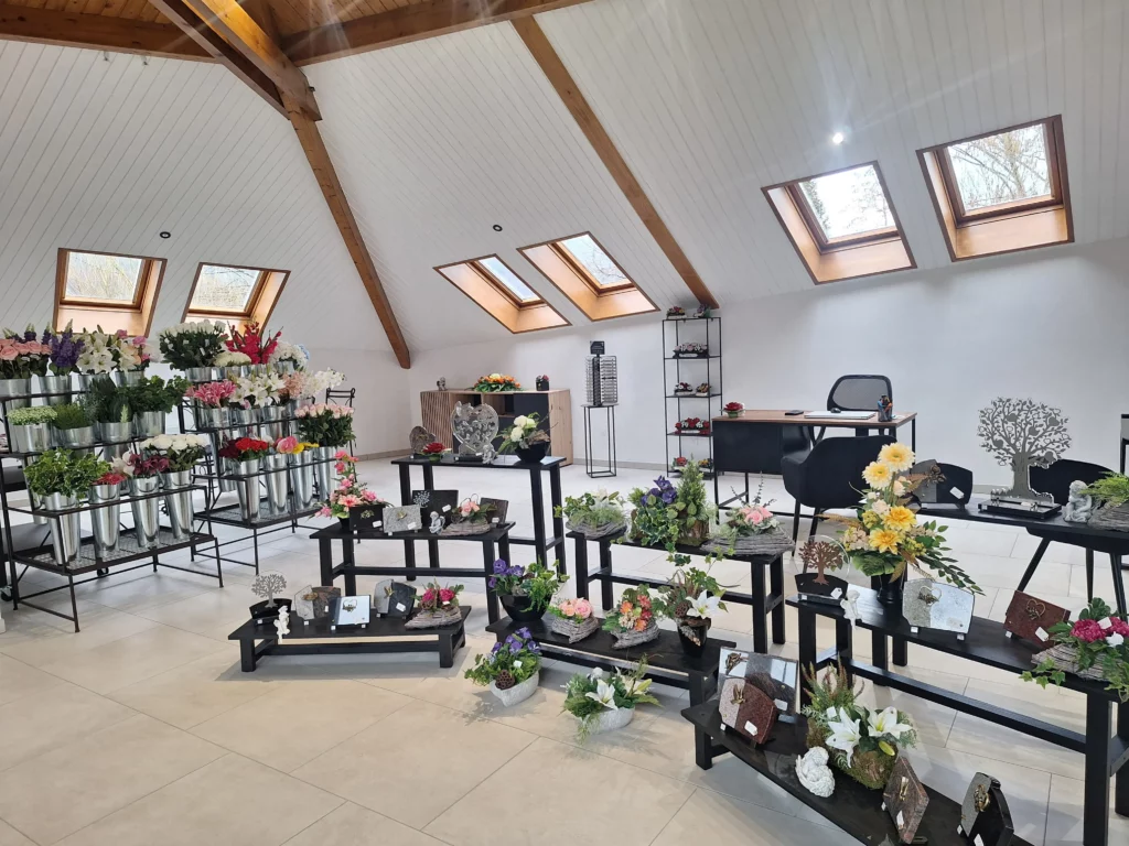 Exposition d'articles funéraires et de fleurs dans un espace d'accueil moderne.