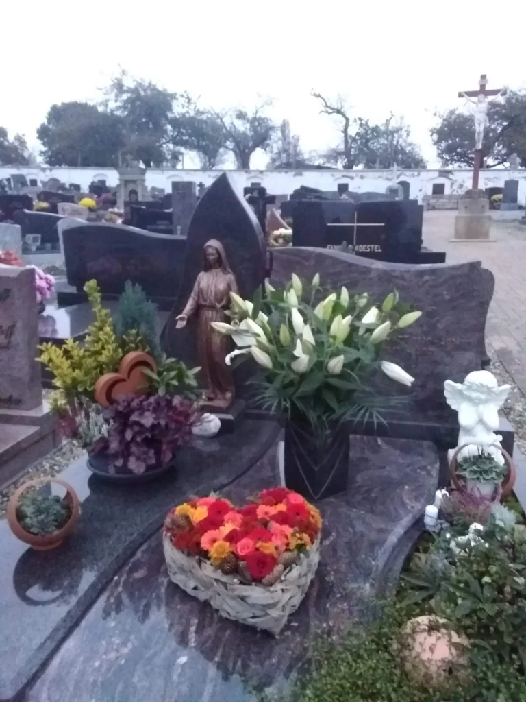 Composition florale en forme de cœur sur une sépulture dans un cimetière.