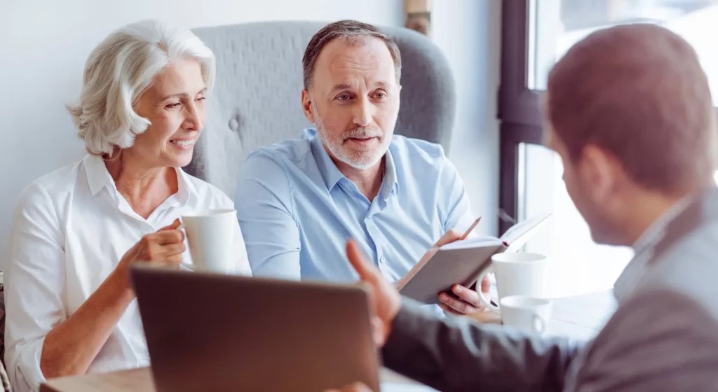 Couple de seniors en discussion avec un conseiller en prévoyance obsèques.